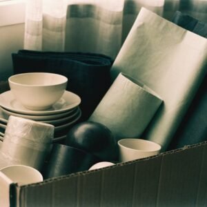 Plain ceramic dishware, textiles and containers packed in a carton