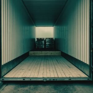 The open rear of a dry-van freight trailer with wrapped pallets loaded at the nose